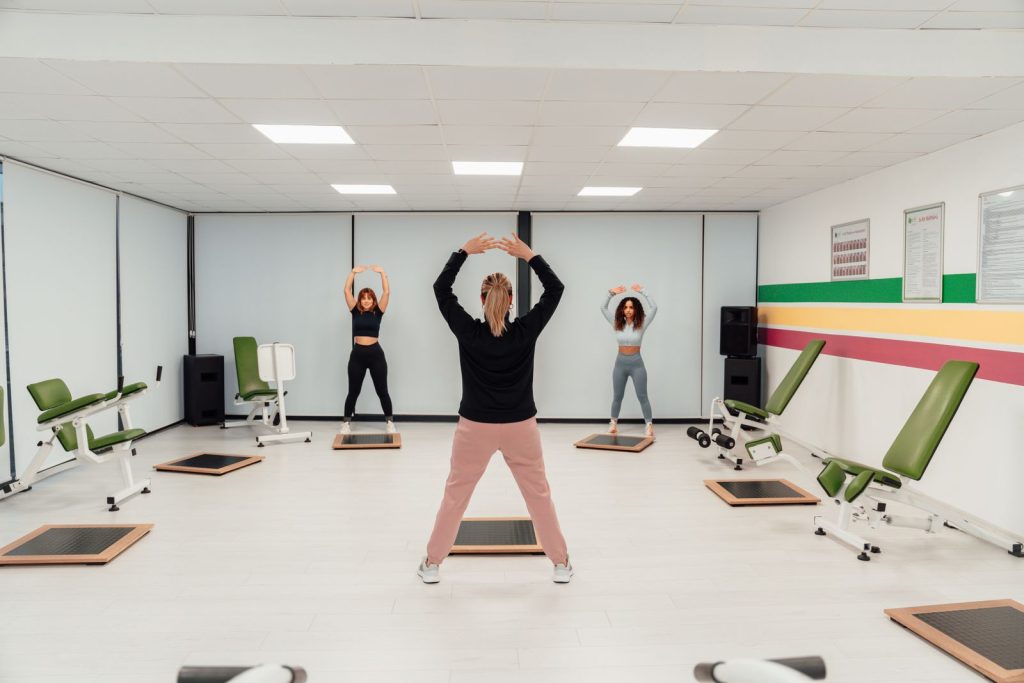 Groupe de femmes suivant un cours collectif de fitness dans une salle de sport