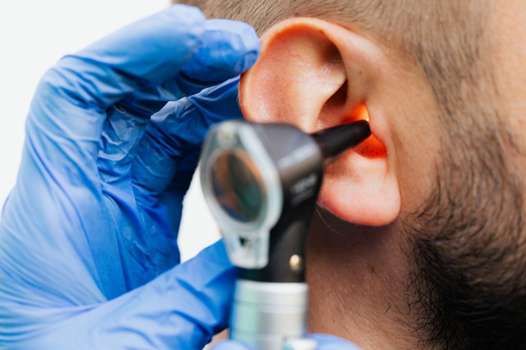 Medecin examinant une oreille a l'otoscope
