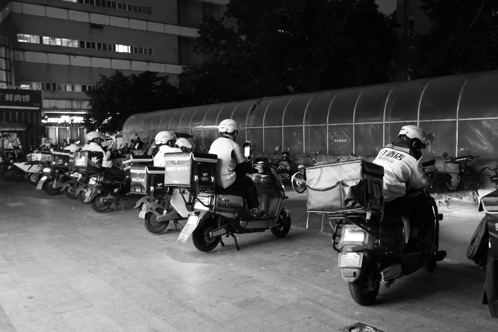 Livreur à scooter dans une rue urbaine la nuit